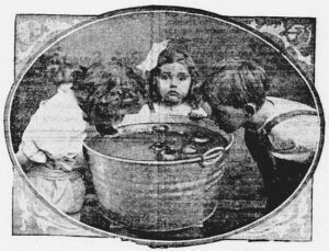 Tres niños intentando atrapar manzanas con la boca en una fiesta de Halloween de 1906